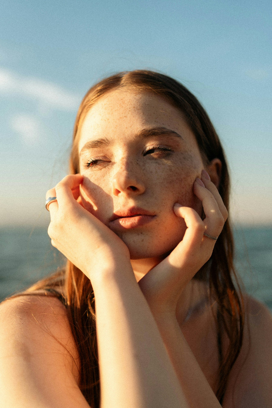 Woman applying skincare in the mirror